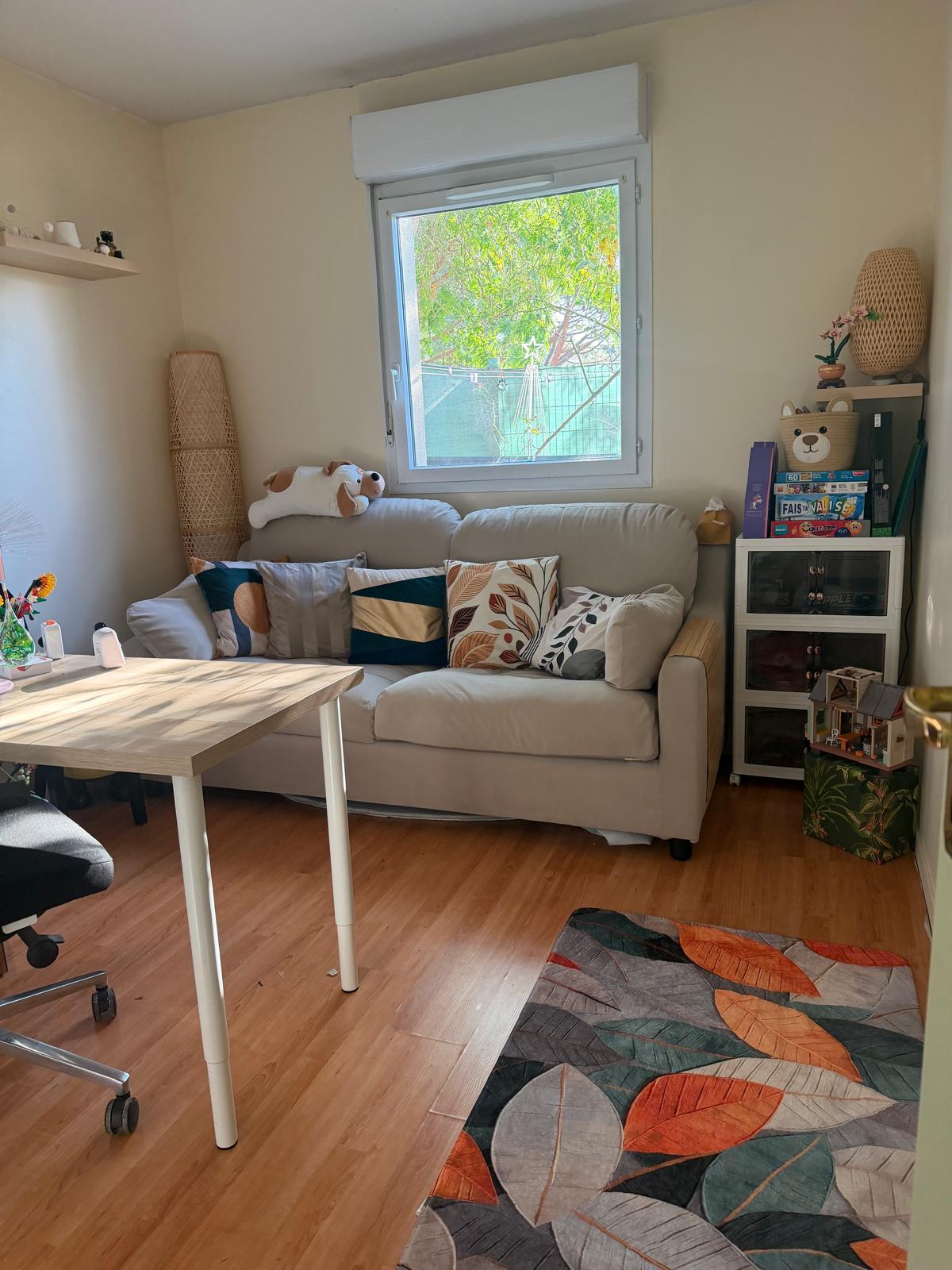 Le cabinet de Reine Valensol à Mérignac : un salon lumineux avec canapé, espace de jeu pour les enfants et bureau.